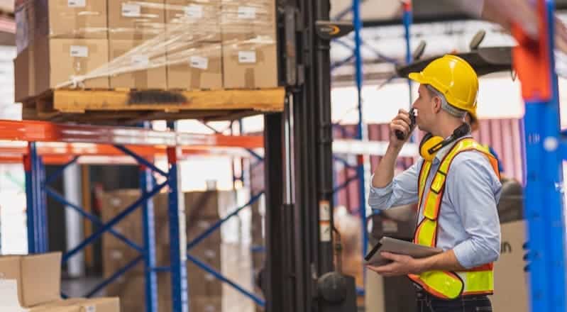 Worker with tablet performing multi-warehouse management.